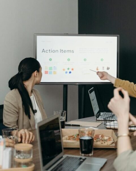Colleagues discussing a presentation of action items in an office setting.